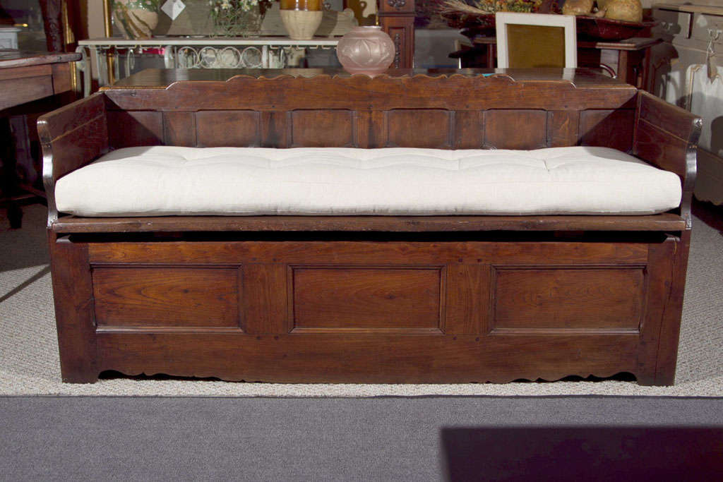 A vintage walnut French Provincial settee with trundle and newly upholstered cushion seat.